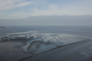 Sand, sky and water background: low tide and sea in the distance