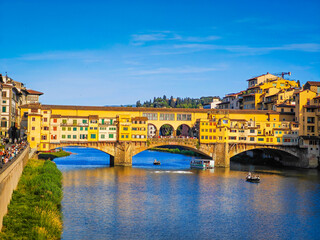 Obraz premium Ponte Vecchio bridge over Arno River in Florence. Picturesque medieval arched river bridge with Roman origins, lined with jewelry and souvenir shops.