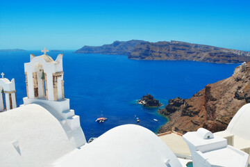 Oia village on Santorini island, Greece. Traditional and famous small bell towers with white houses...