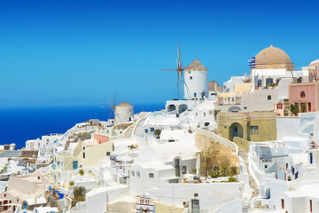 Oia village on Santorini island, Greece. Traditional and famous houses and windmill over the Caldera, Cyclades islands Aegean sea.
