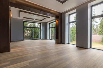 Panoramic windows overlooking the courtyard in an empty room of a luxurious mansion. Beautiful decor. Unfurnished.