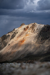 Dramatic Mountain Peak Under Stormy Clouds with Rich Earth Tones