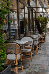 Quintessential Parisian café ambiance on a charming street in the 7th arrondissement. Elegant wicker chairs and wooden tables create an inviting scene perfect for dining, leisure, or urban lifestyle 