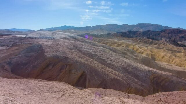 This 4K UHD aerial footage captures the dramatic mountain crest at Zabriskie Point, Death Valley National Park, California. The aerial view reveals the stunning geological formations of the park's ari