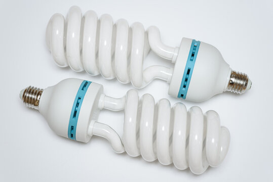two white eco-friendly energy-saving light bulbs with metal base, isolated on white background