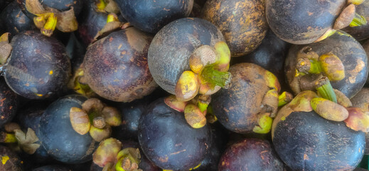 Fresh mangosteen fruits piled together in a local market showcasing vibrant colors and organic texture