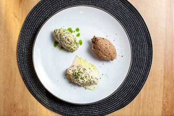 Elegant gourmet appetizer platter with pate and salad served on a white plate with garnishes