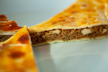 Close-up view of a slice of traditional Russian meat pie showcasing its rich filling and golden crust