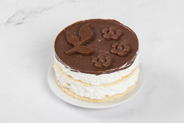 Vegan dessert. Bird's Milk Cake. Vanilla souffle, biscuit, with chocolate on top. On a plate. White background. Close-up
