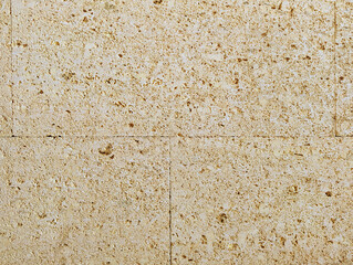 Wall texture background with fossiliferous cream yellow sandstone slabs cladding. Interior and exterior decoration with rustic mediterranean style textured stone and rock tiles.