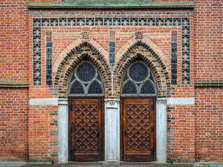 Obraz premium Wooden door and brick wall of the medieval gothic church in Elblag 