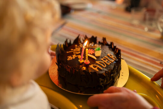 A child is holding a cake with the name Adela on it