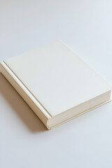Fototapeta premium Blank white book on a light surface. Perfect for book cover designs or presentations.