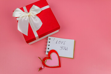 Red gift box, Valentine heart and notepad with handwritten text 
