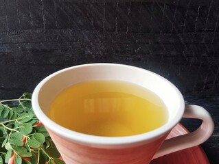 Boiled moringa leaves water in glass 