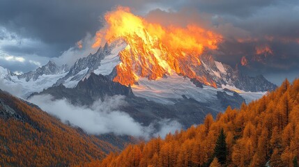 Fototapeta premium Mountains glow under setting sun with autumn trees.