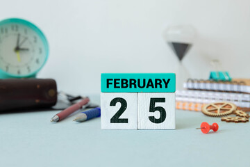 Cube shape calendar for February 25 on wooden surface with empty space for text