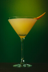 Refreshing Citrus Martini with Orange Garnish and Mint Vibrant Cocktail Against Lush Green Backdrop