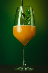 Refreshing Orange Cocktail with Mint Garnish in a Stylish Glass Vibrant Summer Drink Against Lush Greenery