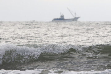 波と遠くに見える漁船