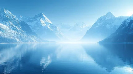 Serene winter lake reflecting snowy mountains.