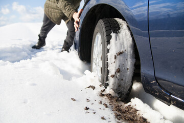 雪道でスタックした車を押す