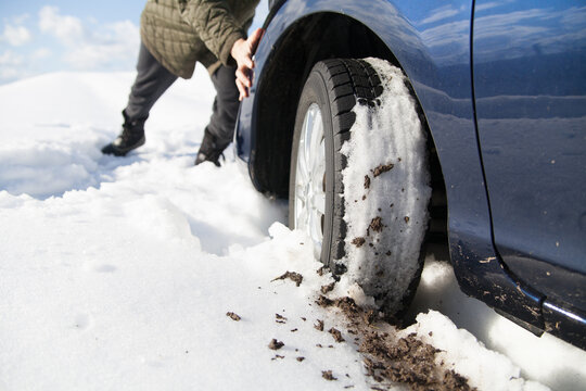 雪道でスタックした車を押す