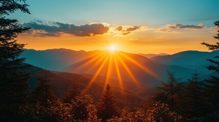 Naklejka premium Sun rises over layered mountains.