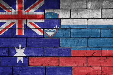 colourful painted big flag of australia and flag of slovenia on a massive old brick wall...