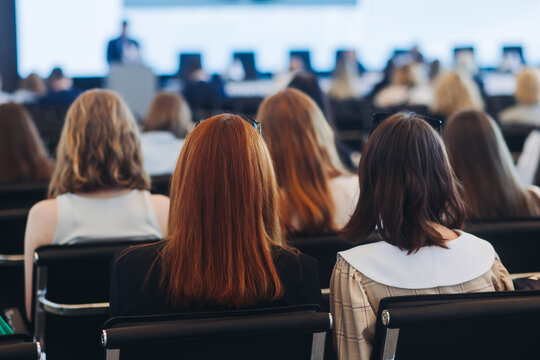 Conference with female audience, the symposium meeting, participants attendees in room hall listen to lecturer, group of women on a congress together listen to speaker on stage at master-class event - Powered by Adobe