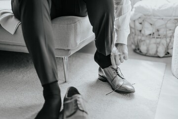 Man Adjusting Laces on a Couch