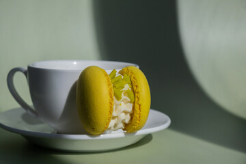 Sweet macaron dessert Cup of green plant based matcha tea latte in cozy morning atmosphere. Creative holiday romantic date idea. Herbal prebiotic fiber superfood beverage antioxidant-rich immunity