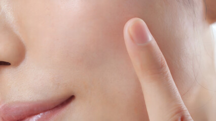 Obraz premium 人差し指でそっと触れられた、日本人女性の頬のクローズアップショット