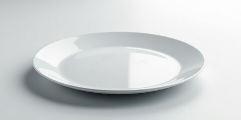 A single, pristine white dinner plate rests on a smooth, bright surface, ready for a culinary creation or a simple presentation.