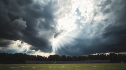 Obraz premium Empty football stadium under dramatic sky, showcasing solitude and anticipation in sports, symbolizing moments of pause before the roar of the crowd returns.