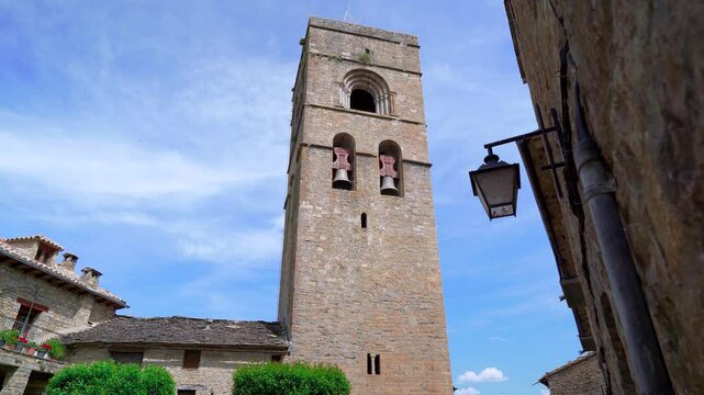Calle de un pueblo medieval con una iglesia con una torre al fondo y movimientos de c&aacute;mara. Desde Ainsa, Huesca, Arag&oacute;n, Espa&ntilde;a, Europa.
