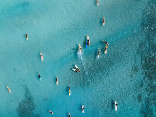Drone Aerial View of Surfers Riding Waves in Hawaii Sea with Surfboards in the Blue transparent Ocean 