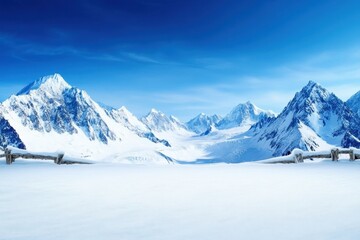 Obraz premium Snowy mountain range with peaks and valleys under a clear blue sky in winter season
