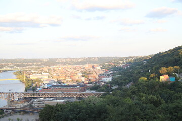 High level view of the city skyline from the river in downtown Pittsburgh, Pennsylvania during twilight. 