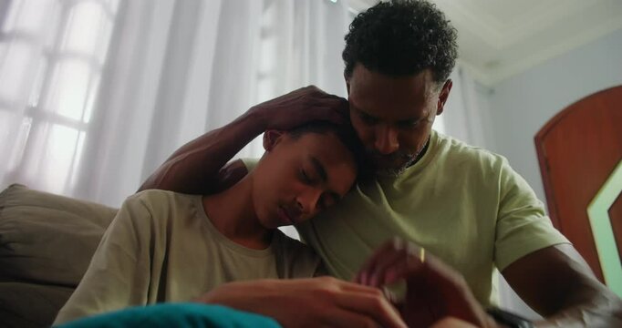 Father supporting his sad teenage son through a difficult time, offering empathy and guidance, strengthening their bond and fostering trust in a nurturing family relationship