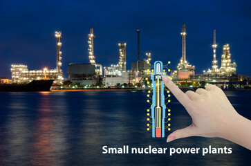Small nuclear power plant icon and a woman's hand on natural background.Alternative energy for the...