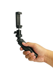 Naklejka premium Hand holding Mini tripod with phone holder isolated on white background.