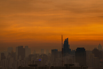 Urban skyline at dusk with orange skies, hazy air, and visible PM2.5 pollution. A striking view highlighting the beauty of twilight and the impact of poor air quality.