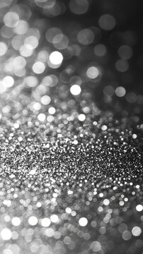 Fototapeta Silver glitter sparkles on dark background, bokeh effect