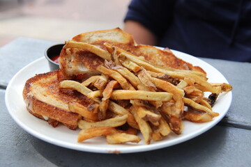 Plate full of sandwiches and french fries at a restaurant	