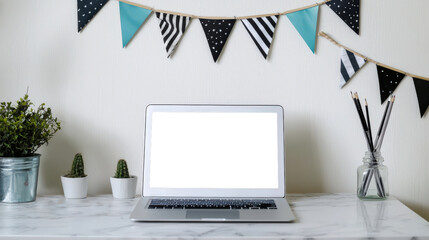 Fototapeta premium Laptop mockup for website presentation. There is an open laptop with a white screen on the table, and festival flags hang on the wall behind it. There are cacti, a green potted plant, and pencils
