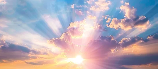 Heavenly sunrise. Peaceful pastel colors paint the sky as sun rays burst through the clouds. © Init