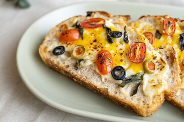 open sandwiches sourdough bread toast for breakfast or brunch with cheese tomato olives.