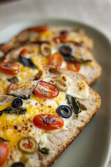 open sandwiches sourdough bread toast for breakfast or brunch with cheese tomato olives.