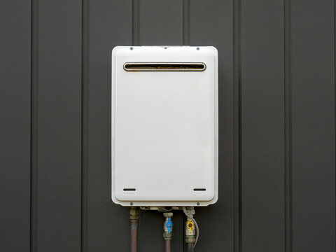 Modern external continuous flow gas water heater mounted on house wall